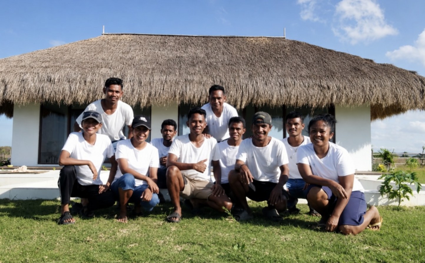 Part of the Eco Beach City team outside a finished home in Sumba